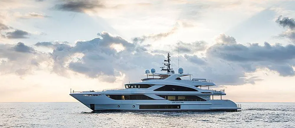 White motor yacht on open water beneath a cloudy sky