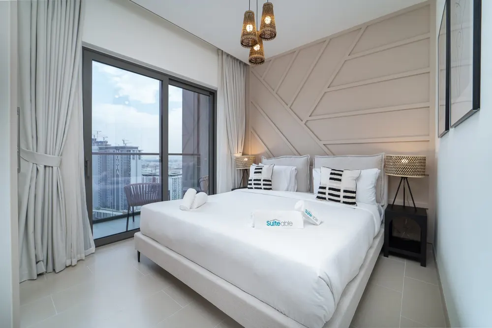Bright bedroom with a double bed and balcony doors