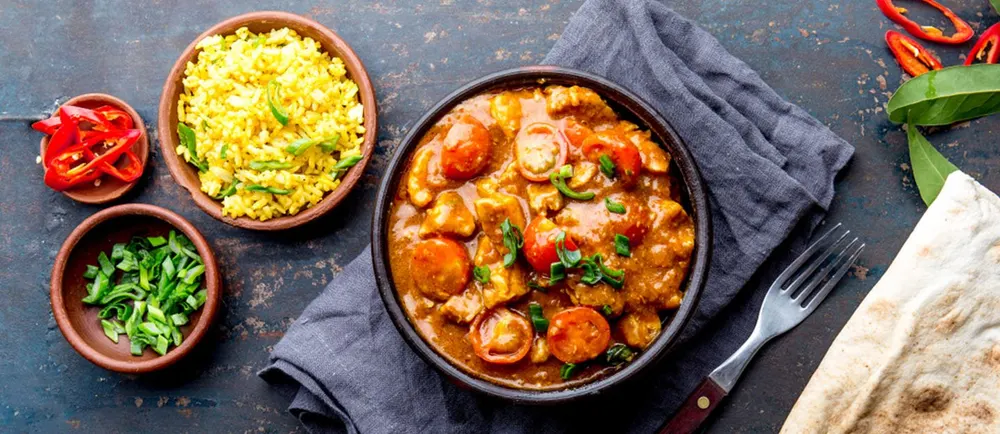 Curry avec riz, pain plat et petits bols de légumes