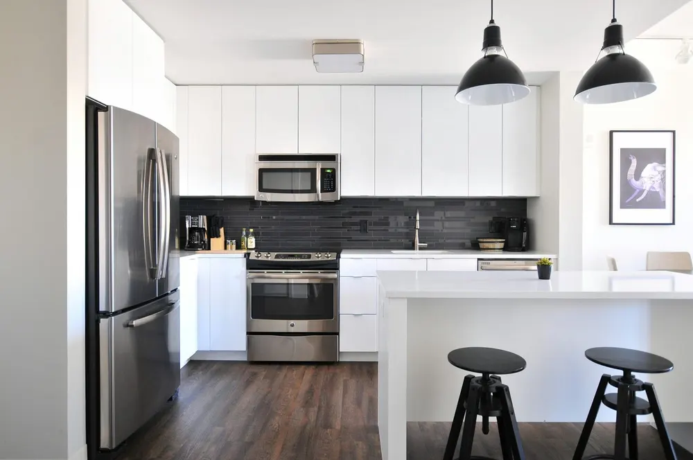 White kitchen with a breakfast bar and black pendant lights