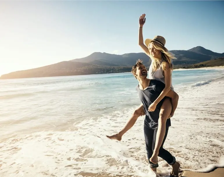 Pareja divirtiéndose en una playa soleada