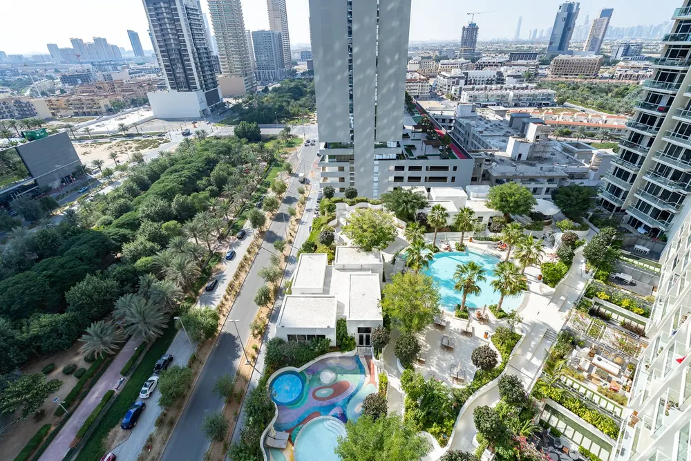 High-rise view of landscaped gardens, pools and surrounding buildings