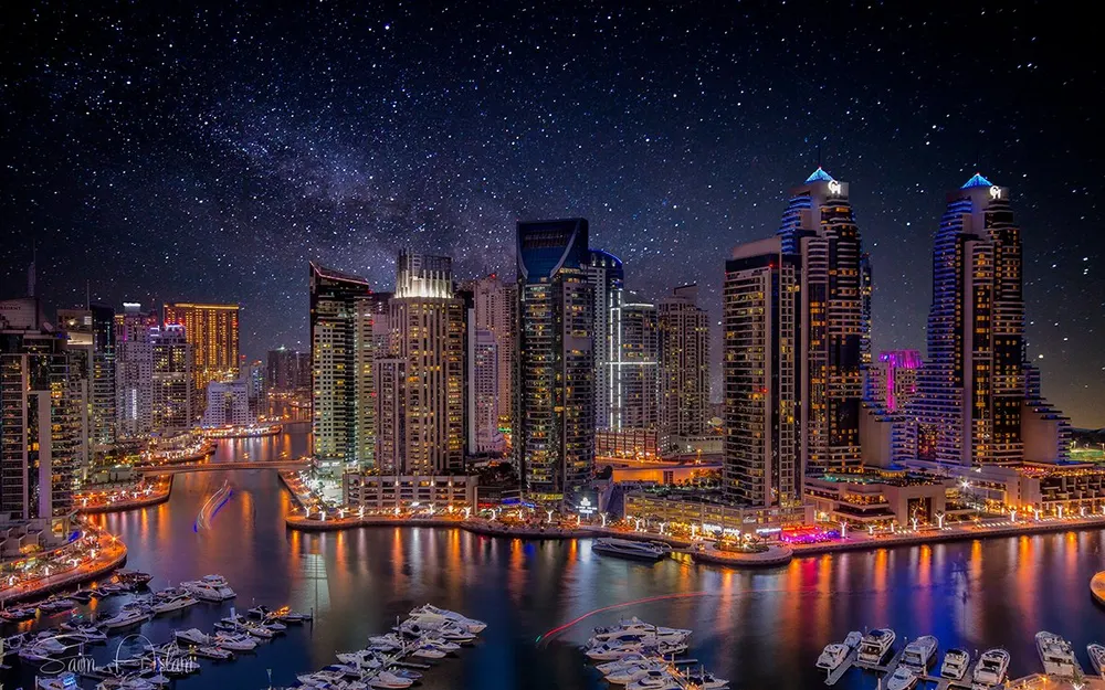 Tours illuminées de Dubai Marina se reflétant dans l’eau la nuit