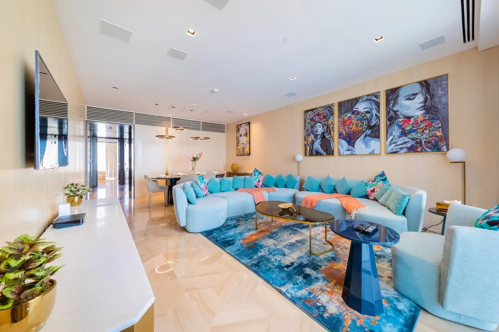 Spacious living room with turquoise sofas and colourful artwork