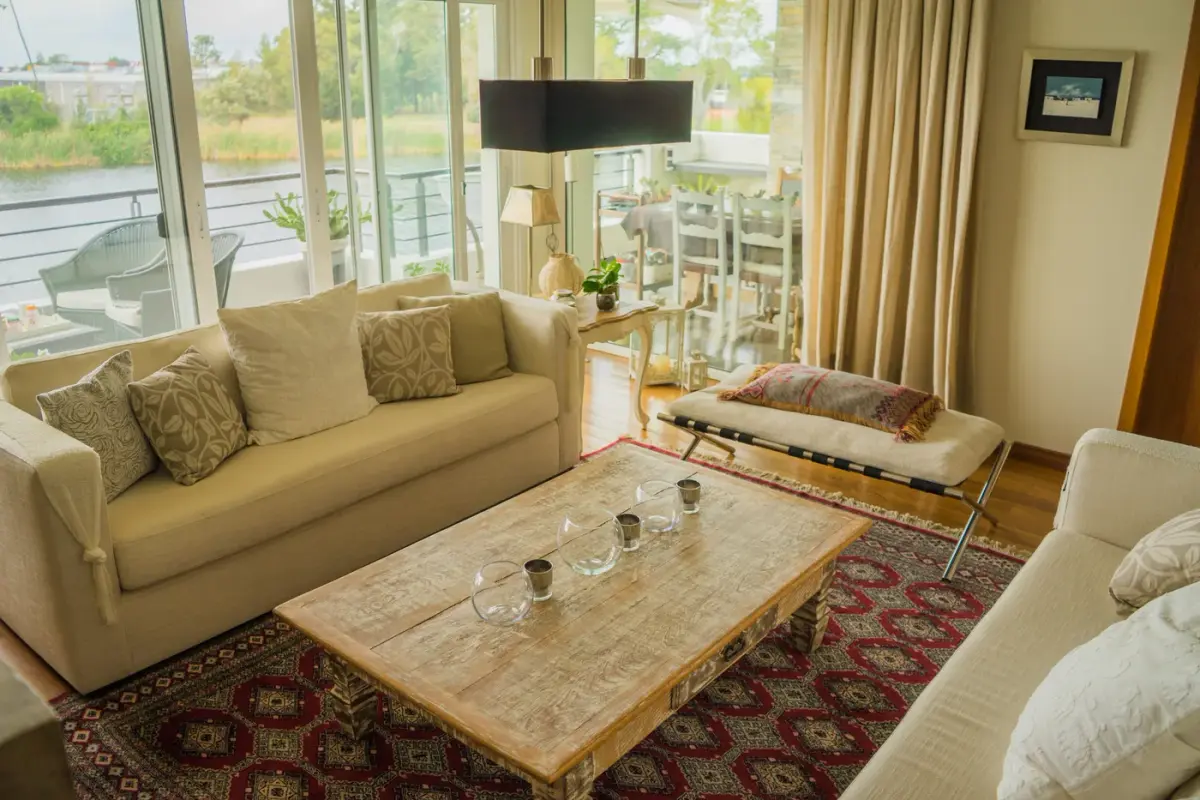 Living room with beige sofas, a patterned rug and large windows
