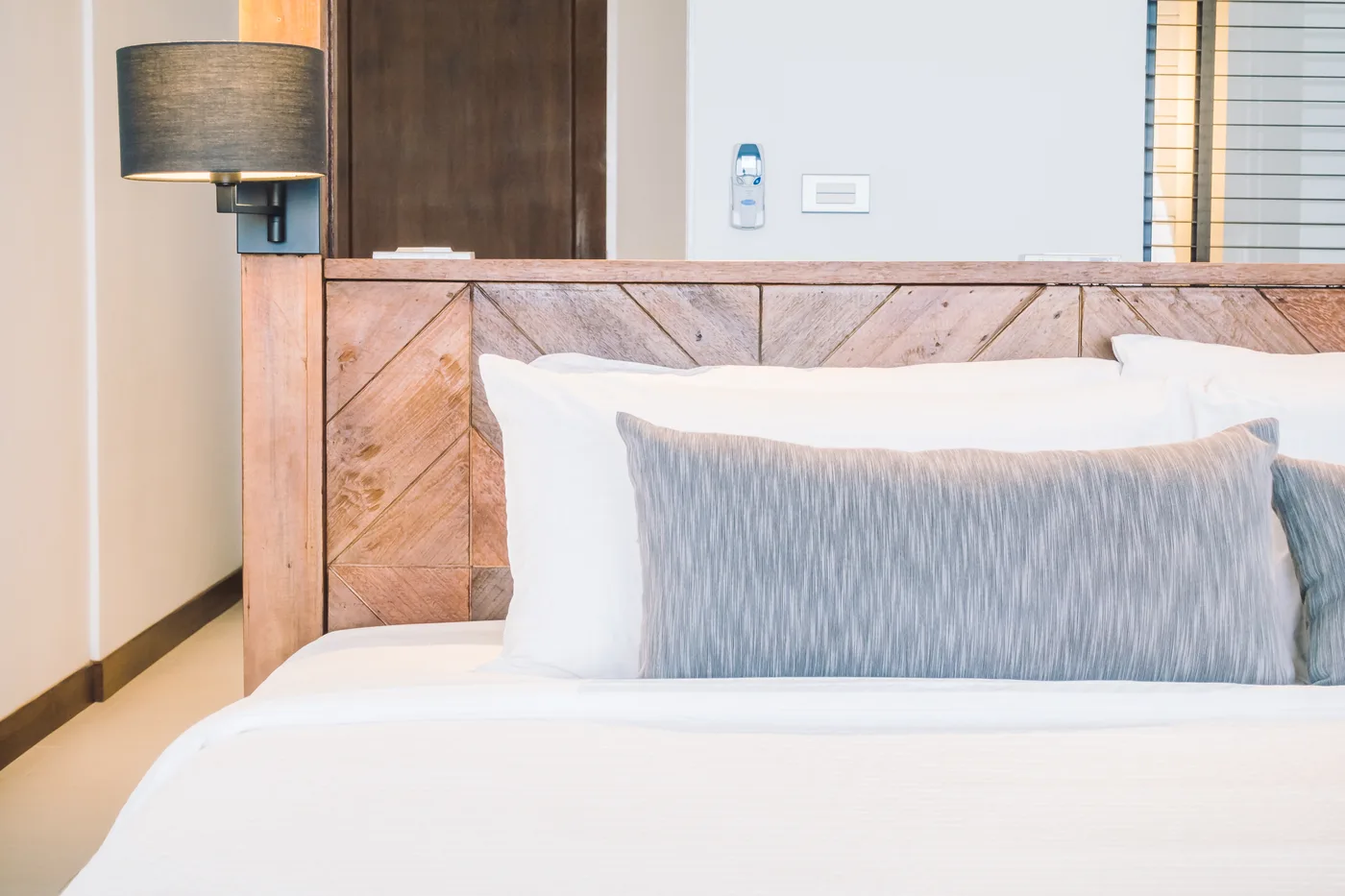 Pillows against a pink upholstered headboard