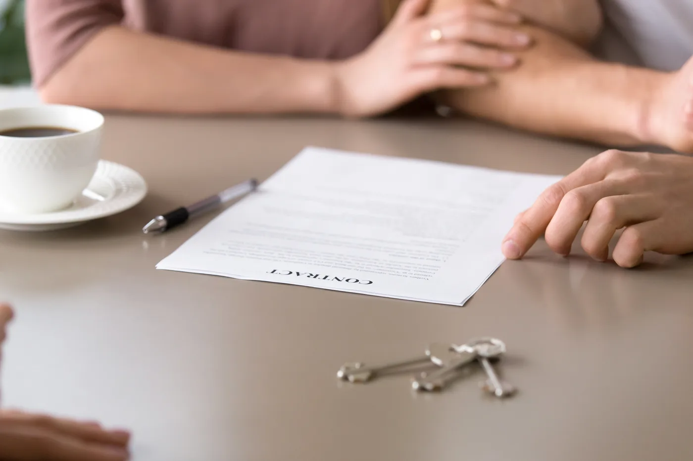 People reviewing paperwork beside apartment keys