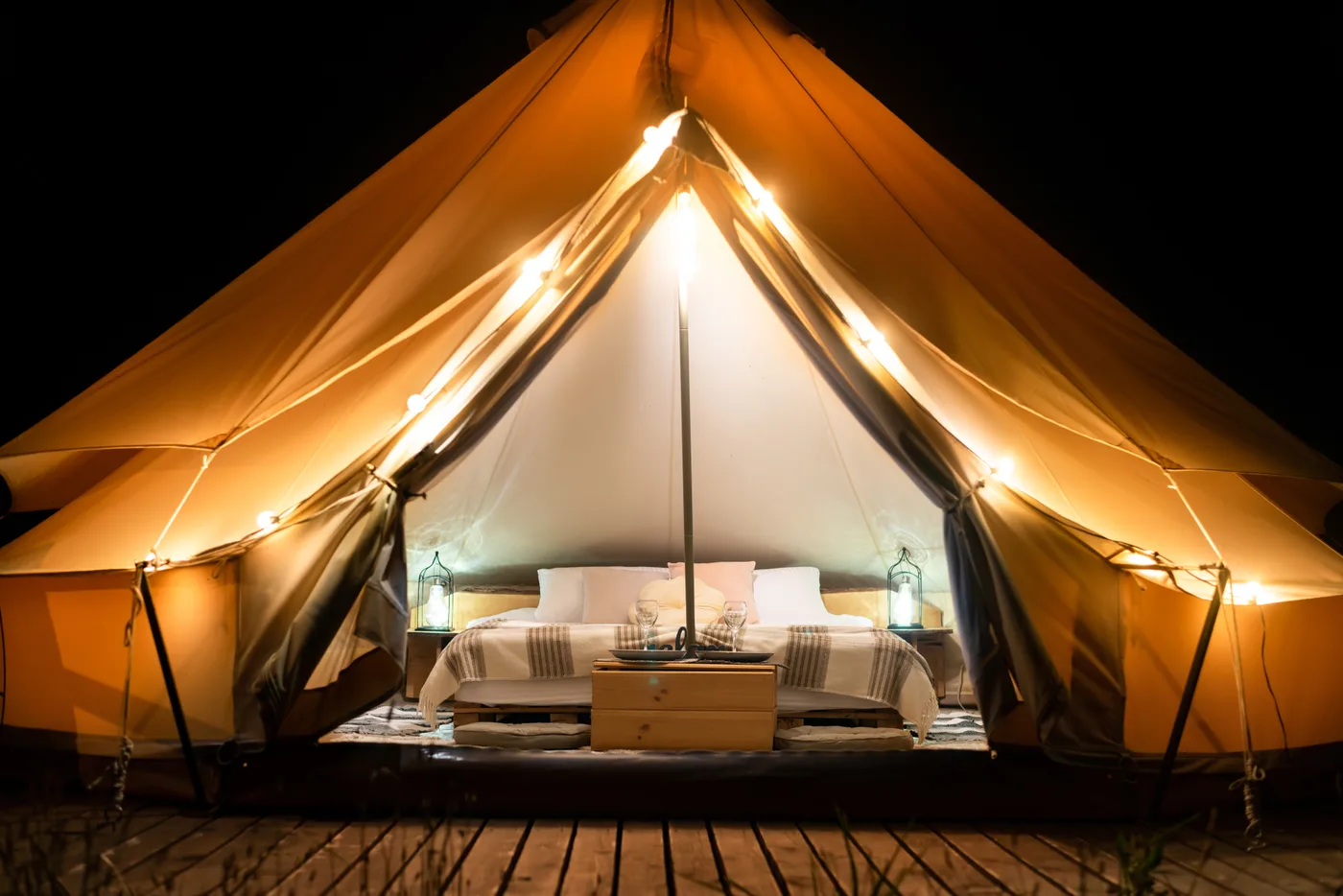 Tente en toile meublée éclairée chaleureusement la nuit