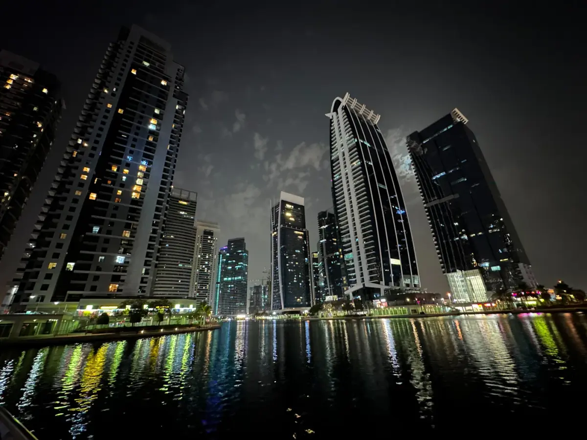 Jumeirah Lakes Towers iluminadas junto al lago de noche