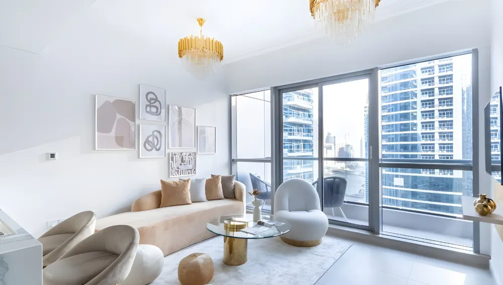 Bright living room with pale furniture and floor-to-ceiling windows