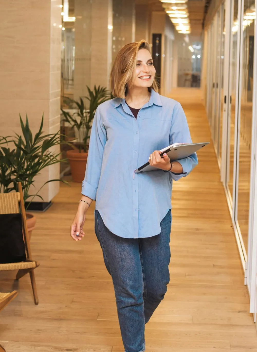 Employée d’entretien traversant un couloir avec du matériel de nettoyage