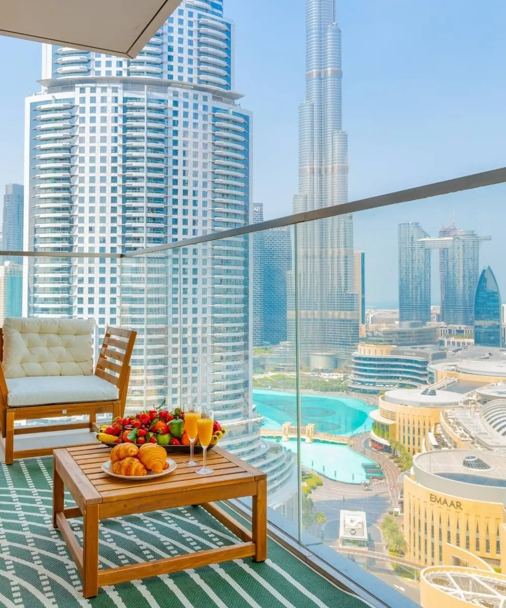 Apartment balcony with wooden chairs overlooking Dubai high-rises
