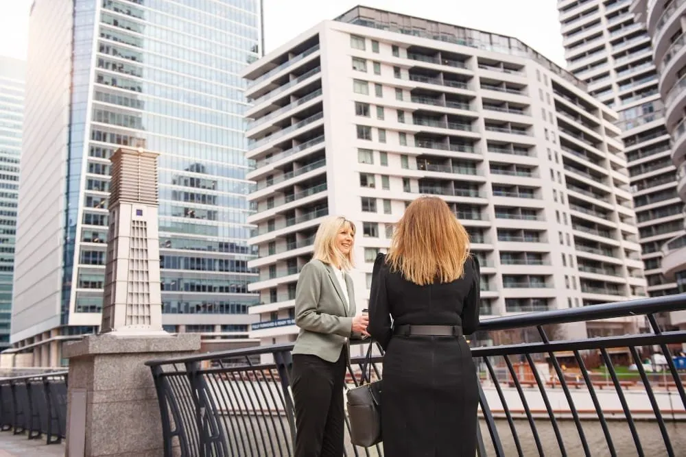 Woman on a balcony facing nearby residential towers