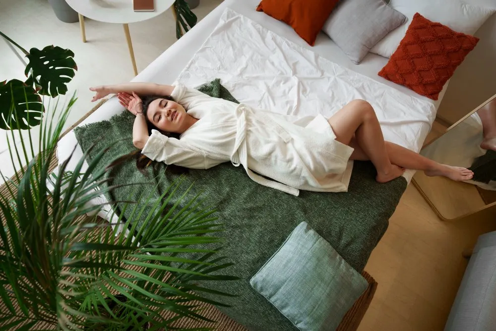 Ospite che si rilassa sul letto in una stanza ricca di piante