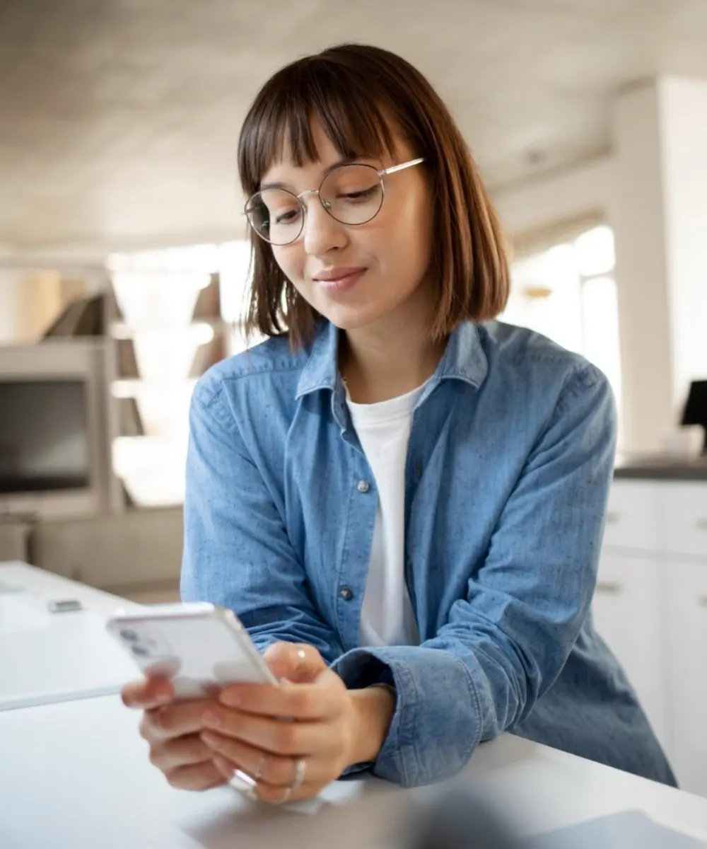 Woman looking at a smartphone while seated indoors