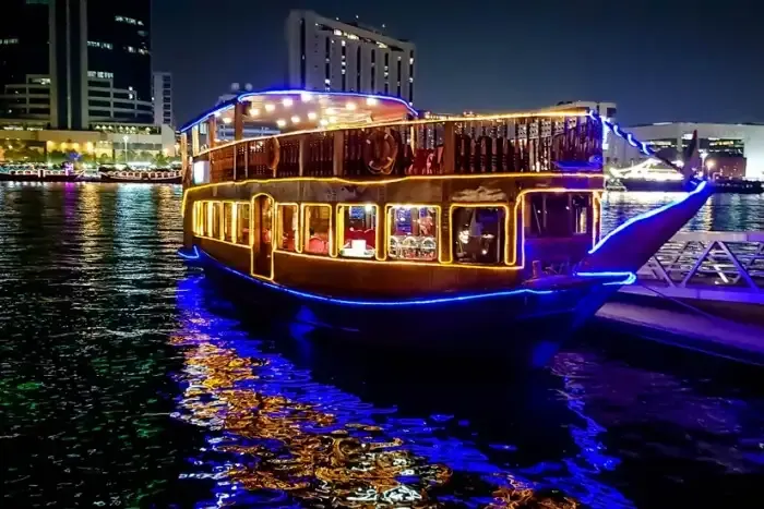 Barco de madera iluminado junto al paseo marítimo de noche